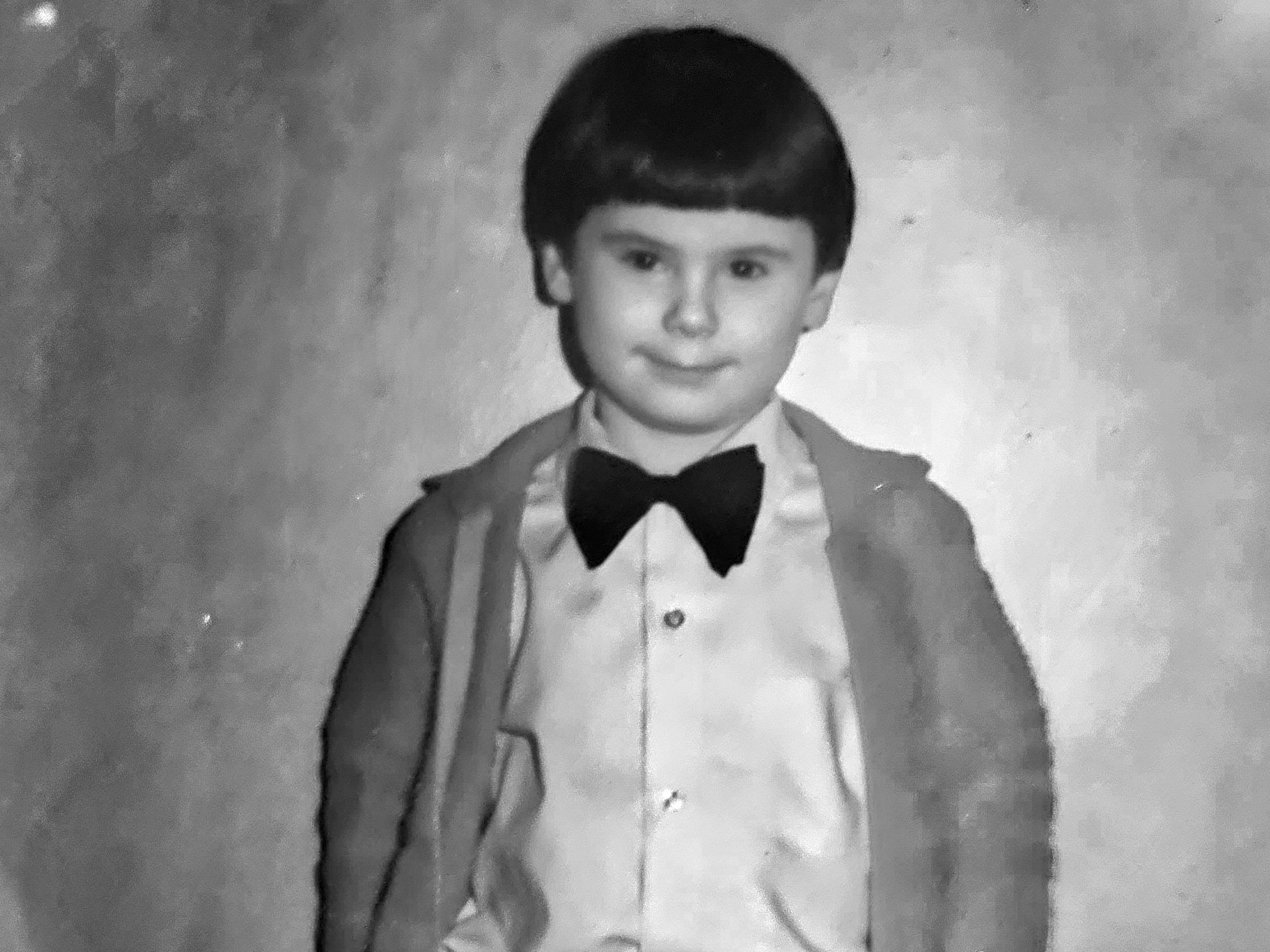 Eric Hosford at a young age wearing a bow tie and light jacket